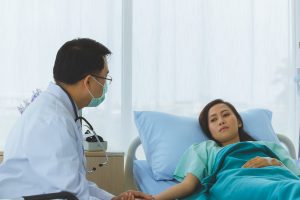 Male Asian Doctor offers chronic illness management counseling for a female adult patient in Atlanta, GA.