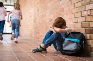 Young boy sitting on the ground hugging his knees because he is upset | Positive Discipline | Child & Teen Counseling in Atlanta, GA 30076