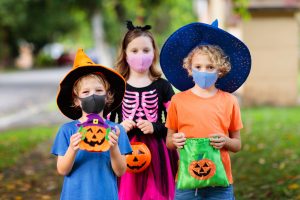 cute kids trick or treating wearing masks. Their parents struggled to determine how to celebrate the holidays during COVID-19. They got online therapy in Georgia to cope with anxiety and decision fatigue at Wellview Counseling