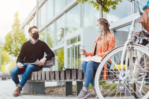 College students spending time outdoors wearing masks and social distancing. If you're struggling with college stress during the pandemic consider online therapy in Georgia to help you cope. Meet with an online therapist from Wellview Counseling today