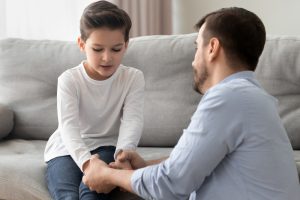 A worried father takes his son by the hands as they talk through a touchy subject. This could represent what a tough talk might look like between a father and his son. We offer child counseling in Roswell, GA to support you and your child. Contact a child therapist today for childhood trauma treatment and more. 