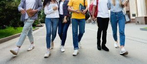 A group of students walk with one another while holding books. Counseling for teens in Roswell, GA can offer support with teen counseling in Atlanta, GA. 30076