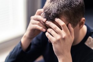 A close up of a teen covering their face. This could represent the big emotions DBT therapy in Roswell, GA can help you cope with. Learn more about individual counseling in Roswell, GA and more by contacting a DBT therapist in Roswell, GA today. 30076