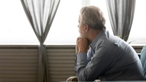 A middle aged man looks out the window while resting their head on their fists. A therpaist in Roswell, GA can offer support with past pain with trauma therapy Roswell, GA and other services. Learn more about childhood trauma treatment in Roswell, GA and more! 30076