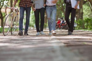 Photo of four college students walking together. This photo represents how social anxiety can make social situations uncomfortable. We offer anxiety counseling in Roswell, Georgia to help you feel more confident in social situations.