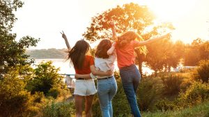 Photo of three teen girls jumping into the air representing how teen therapists can help teens and young adults build stronger friendships