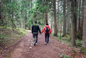 Photo of a man and a woman walking in the forest. This photo represents how DBT therapy in Roswell, GA can give you the tools to improve your relationship.
