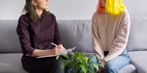 Shows a teen talking to a teen therapist in Roswell, GA about their social anxiety. Represents how teen counseling atlanta, ga is a great support for those struggling with social anxiety and looking to find a job as a teen.