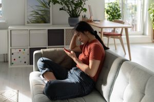 Shows a person procrastinating on the couch. Represents how individual counseling in Milton, GA will support you overcoming your perfectionism. Search "anxiety treatment roswell, ga" today!