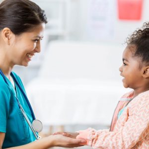 Shows a doctor holding a child's hands and talking to her. Represents how play therapy in alpharetta, ga and a play therapist in alpharetta, ga are important to child with chronic illnesses.